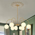 Modern Brass Curved Arm Chandelier | 9-Light Opal Glass Globe Pendant