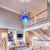 Modern Chihuly blown glass chandelier hanging in a living room with a staircase in the background